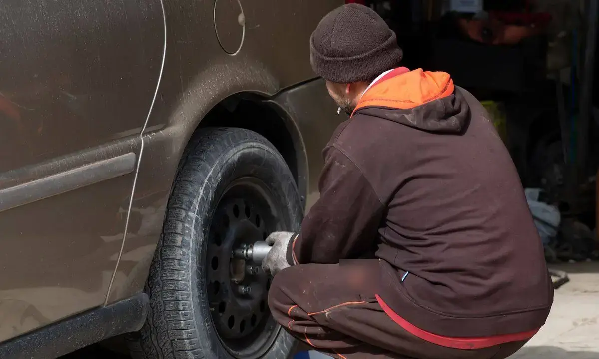 Técnico desmontando la llanta de un carro